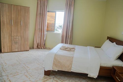 a bedroom with a bed and a window at Résidence Romacy, appartement 2 chambres avec balcon à Ahala, quartier résidentiel de Yaoundé in Yaoundé