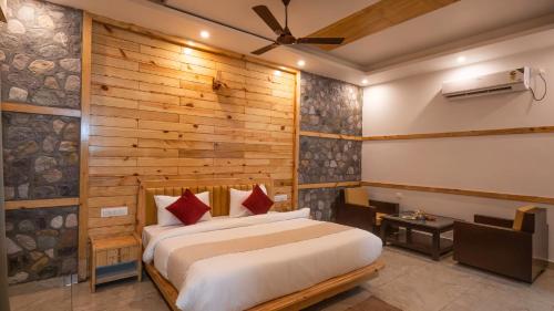 The Forest Resort By 3Tree Group في رامناجار: غرفة نوم بها سرير وجدار خشبي