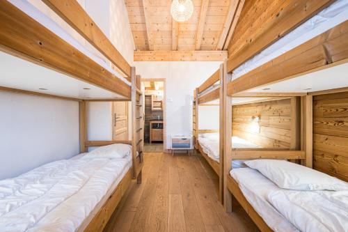 2 stapelbedden in een kamer met houten plafonds bij Chalet Salt Lake in La Toussuire