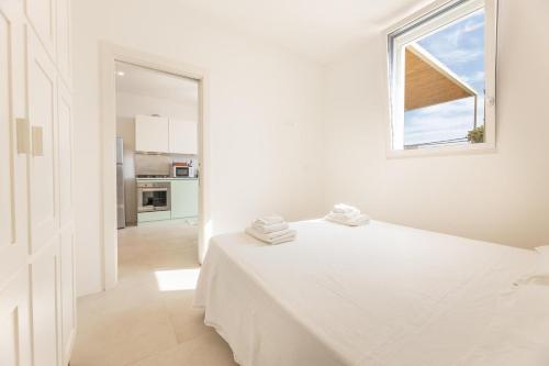 een witte kamer met een bed en een raam bij Appartamento Marinaia Panorama in Marittima