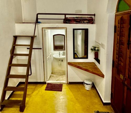 FRENCH RIVERA Heritage Boutique Villa في بونديتْشيري: غرفة بسرير بطابقين وحمام مع حوض