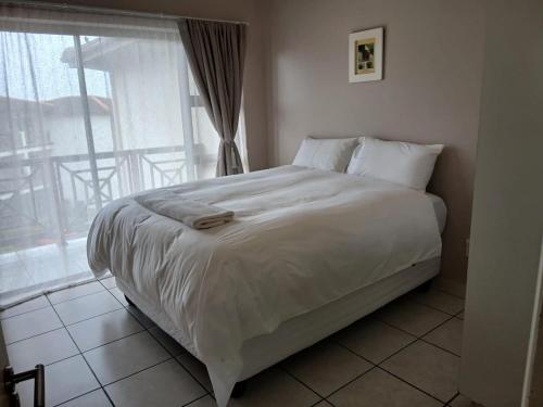 a white bed in a bedroom with a window at 54 Topanga Holiday Accommodation in Margate