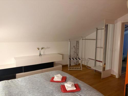 a bedroom with two red towels on a bed at Home Little Star in Gorizia