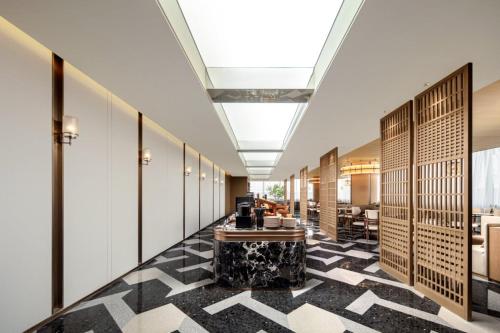 Un vestíbulo con suelo a cuadros blancos y negros. en Atour S Hotel Wuhan Wuchang River Beach, en Wuhan