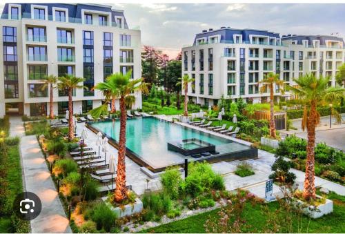 een uitzicht over een zwembad met palmbomen en gebouwen bij Апартамент AZUR PREMIUM in Varna