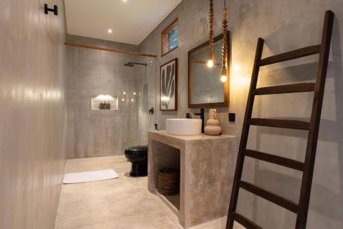 a bathroom with a sink and a toilet and a ladder at Kano Uluwatu in Uluwatu
