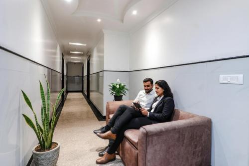 a man and a woman sitting on a couch at FabHotel Rayplus - Prashant Vihar in New Delhi