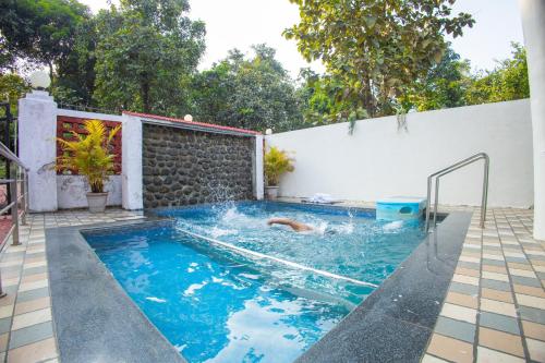 a swimming pool with blue water in a backyard at Mount Aurora I Staymist in Karjat