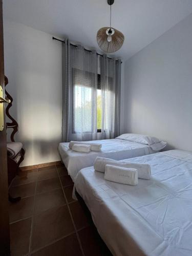 a bedroom with two beds and a window at Casa de mis sueños Castril in El Batán