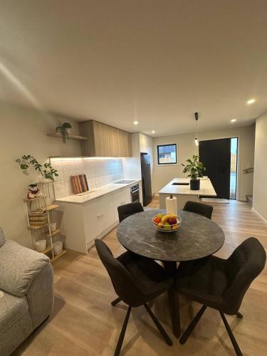 a living room with a table and a kitchen at Double Bedroom in Newly Built Townhouse in Upper Hutt