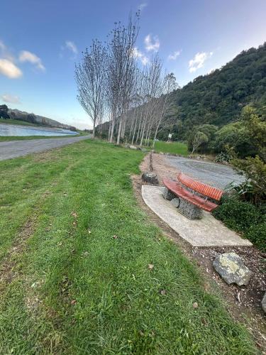 a park bench sitting next to a body of water at Double Bedroom in Newly Built Townhouse in Upper Hutt