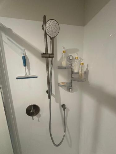 a bathroom with a shower with a shower head at Double Bedroom in Newly Built Townhouse in Wallaceville