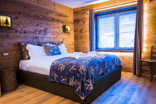 ein Schlafzimmer mit einem Bett und einer Holzwand in der Unterkunft Antico Borgo in Longarone