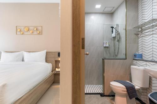 a bathroom with a bed and a shower and a toilet at Finn Hotel in Ban Fang Daeng