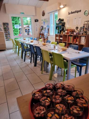een restaurant met een lange tafel en stoelen bij Camping l'île Cariot in Chaillé-les-Marais
