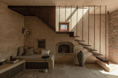a living room with a bed and a staircase at Drakoni Luxury Suite, an Architectural Hideaway, By ThinkVilla in Agios Nikolaos
