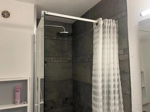 een douche met een douchegordijn in de badkamer bij Maison confortable avec terrasse à Courseulles-sur-Mer in Courseulles-sur-Mer