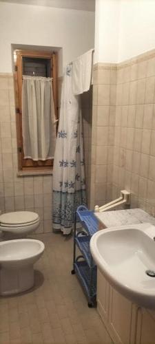 un bagno con due wc, un lavandino e una doccia di Casa Kalida a Santa Maria a Potenza