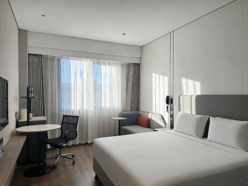 a hotel room with a bed and a desk and chair at Holiday Inn Express Beijing Airport Zone by IHG in Beijing