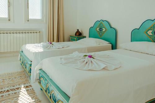 Villa Le Grand Bleu في ميدون: مجموعة من ثلاثة أسرة في غرفة