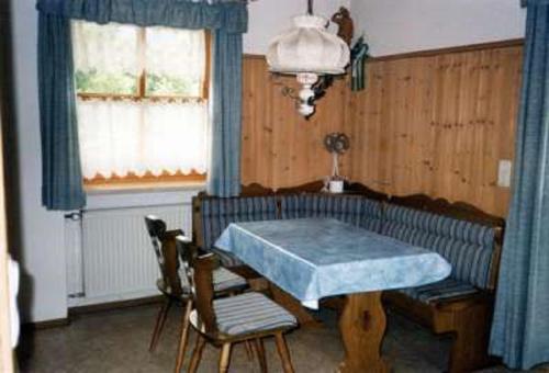 a dining room with a blue table and chairs at Ferienwohnung Max und Klaudia Müller in Drachselsried