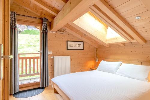 a bedroom with a bed in a room with a window at ORTA Chalet in Les Gets