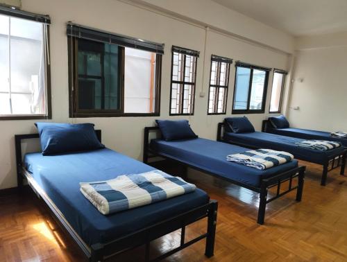 乌汶Doctor Thanut Hostel的带窗户的客房内的三张床