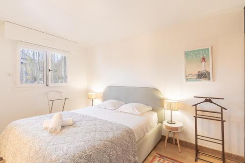 a bedroom with a bed with a teddy bear on it at Le Sommet du Large - Terrasse - Vue Mer - Parking Privé in Trouville-sur-Mer