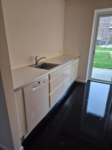une cuisine blanche avec un évier et une fenêtre dans l'établissement Copenhagen Comfort, à Copenhague