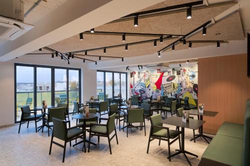 a dining room with tables and chairs and a mural at Cora Sun Apart-Hotel in St Paul's Bay
