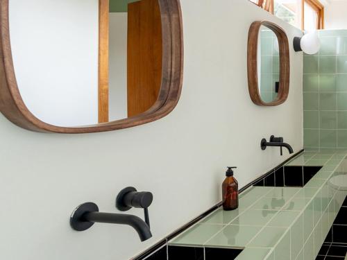 a bathroom with a sink and two mirrors at Céline & Lolo in Nairobi