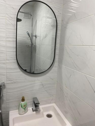 a white bathroom with a mirror and a sink at Angenellyq apartment in Kyustendil