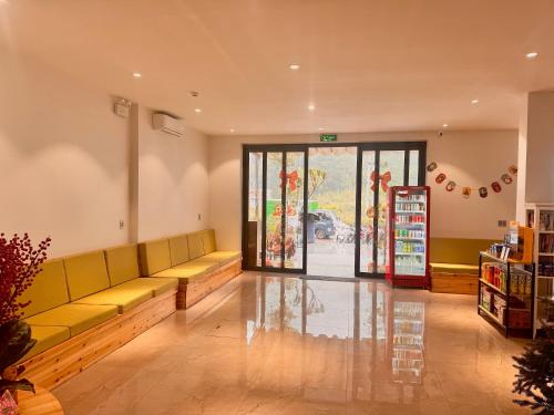 een wachtkamer met een gele bank voor een winkel bij Cozy Hostel and Tours in Ha Giang