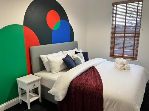 a bedroom with a bed with a colorful wall at 180b Wells Road in Bristol