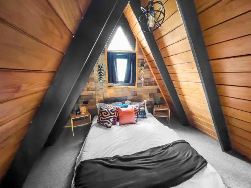 a small bedroom with a bed in a attic at Africa787 A Frame Wood House With Pool in Lajas in Lajas