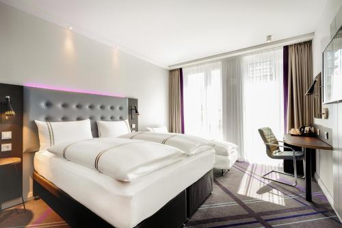 a bedroom with two white beds and a desk at Premier Inn Duisburg City Altstadt in Duisburg