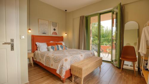a bedroom with a bed and a balcony at Alkyoni luxury apartments Katakolo in Katakolon