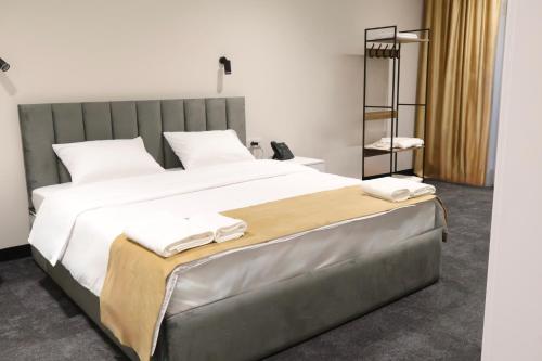 a bedroom with a large bed with towels on it at New Casa Boutique Hotel in Yerevan
