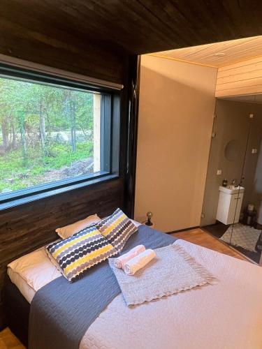 a bedroom with a bed with a large window at Arctic Skyline Villa in Pudasjärvi