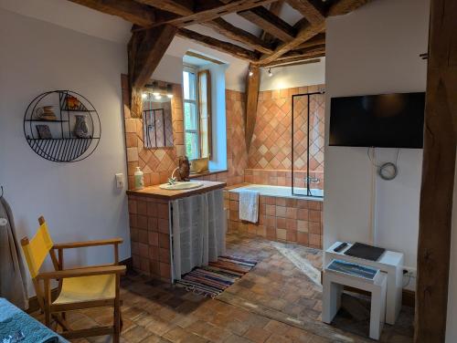 a bathroom with a tub and a sink and a television at Domaine de Bel Ebat in Paucourt
