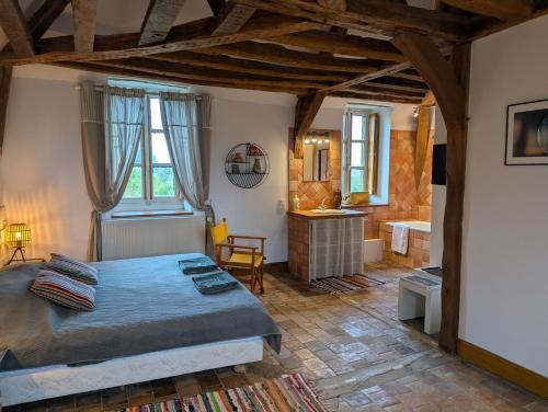 a bedroom with a bed and a bathroom at Domaine de Bel Ebat in Paucourt