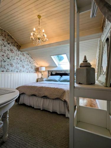 a bedroom with a bed and a chandelier at Chambre Verte, La Bastide in Rosières