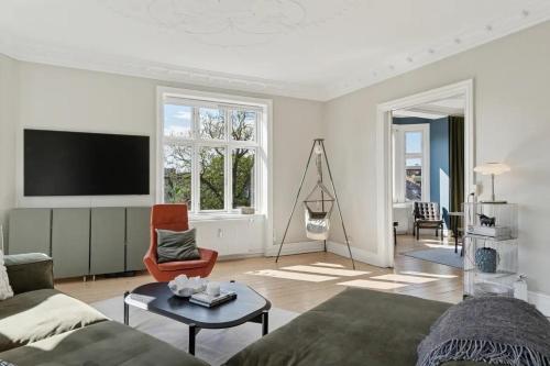 a living room with a couch and a tv at Charming Luxury Flat Nørrebro I Super Rare Find in Copenhagen