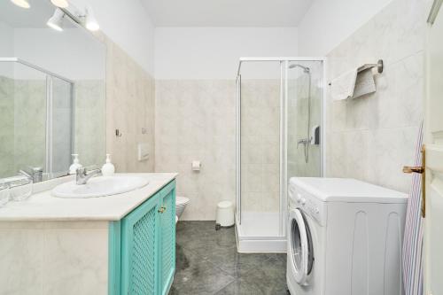 a bathroom with a sink and a washing machine at Apto 2 Almoraide Suites in Nerja