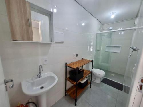 a bathroom with a sink and a shower and a toilet at Espaço inteiro e tranquilo in São José