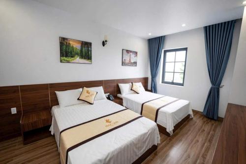 a hotel room with two beds and a window at Mai Linh Hotel in Ha Long