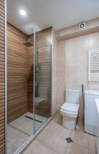 a bathroom with a toilet and a glass shower at Atrium New Gudauri GN in Gudauri