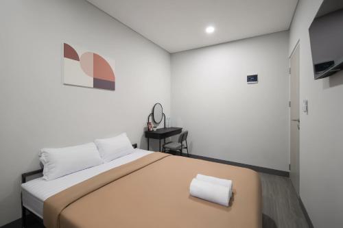 a bedroom with a large bed with a towel on it at Cove Anasera in Jombang