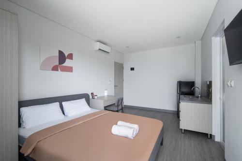 a bedroom with a large bed and a television at Cove Anasera in Jombang