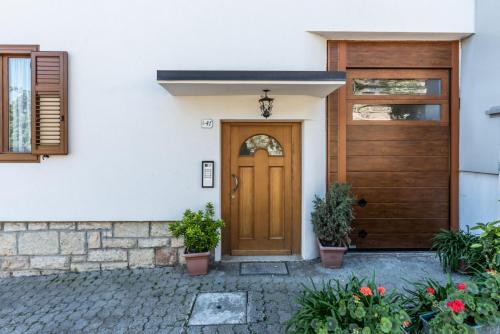 una porta d'ingresso in legno di una casa con piante in vaso di Dimora al Peller Tuenno OSPITAR a Tuenno
